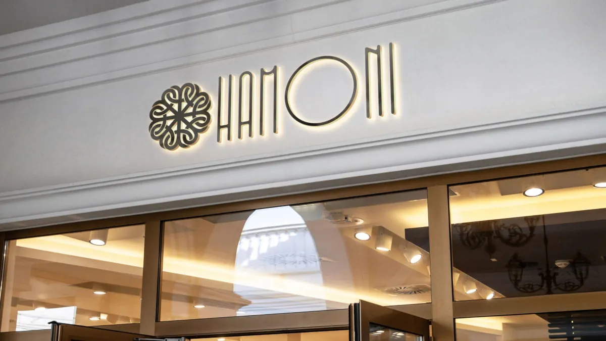 Fachada da Clínica Hamoni, com o logotipo iluminado sobre a entrada de vidro
